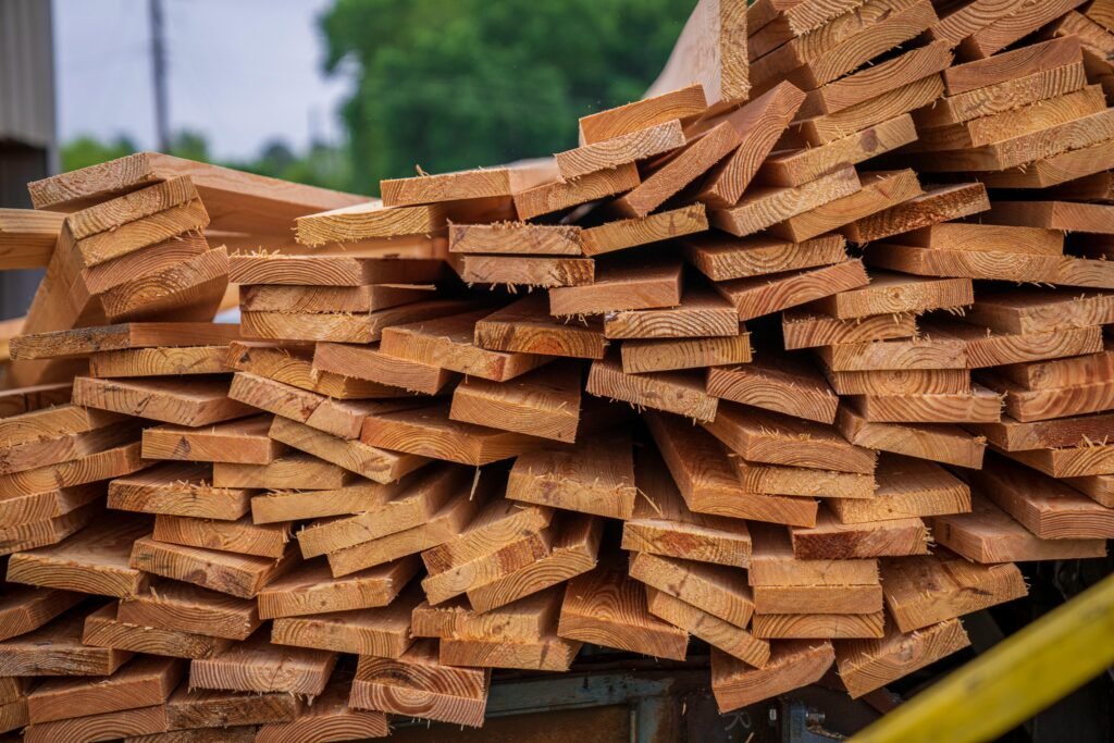 pexels-photo-12278587-12278587 Close-up view of stacked lumber in an outdoor setting, ideal for carpentry projects.